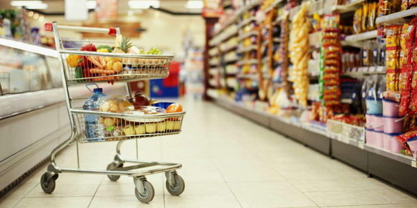 An image of super market with shopping cart filled with grocery items which shows 'modern trade format'