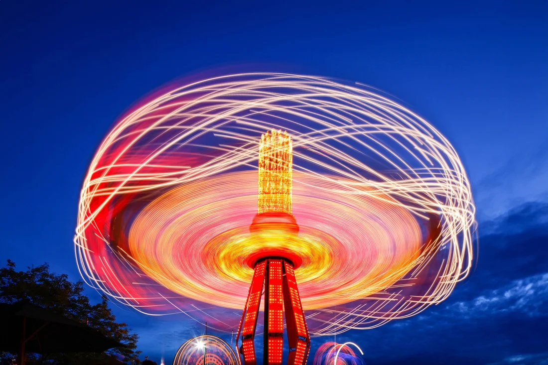 Long exposure of spinning chain swing at carnival at night