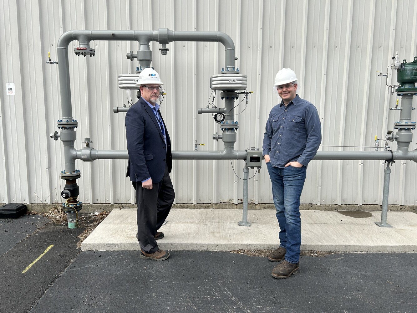 UGI employee and brewery employee stand in front of gas meter.